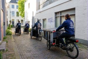 Klussers fietsen door straat in binnenstad